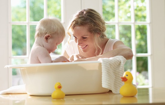 девушка купает малыша